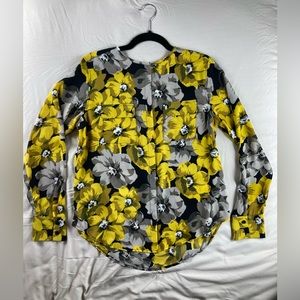 Floral button up Woman’s shirt with no collar and breast pockets.